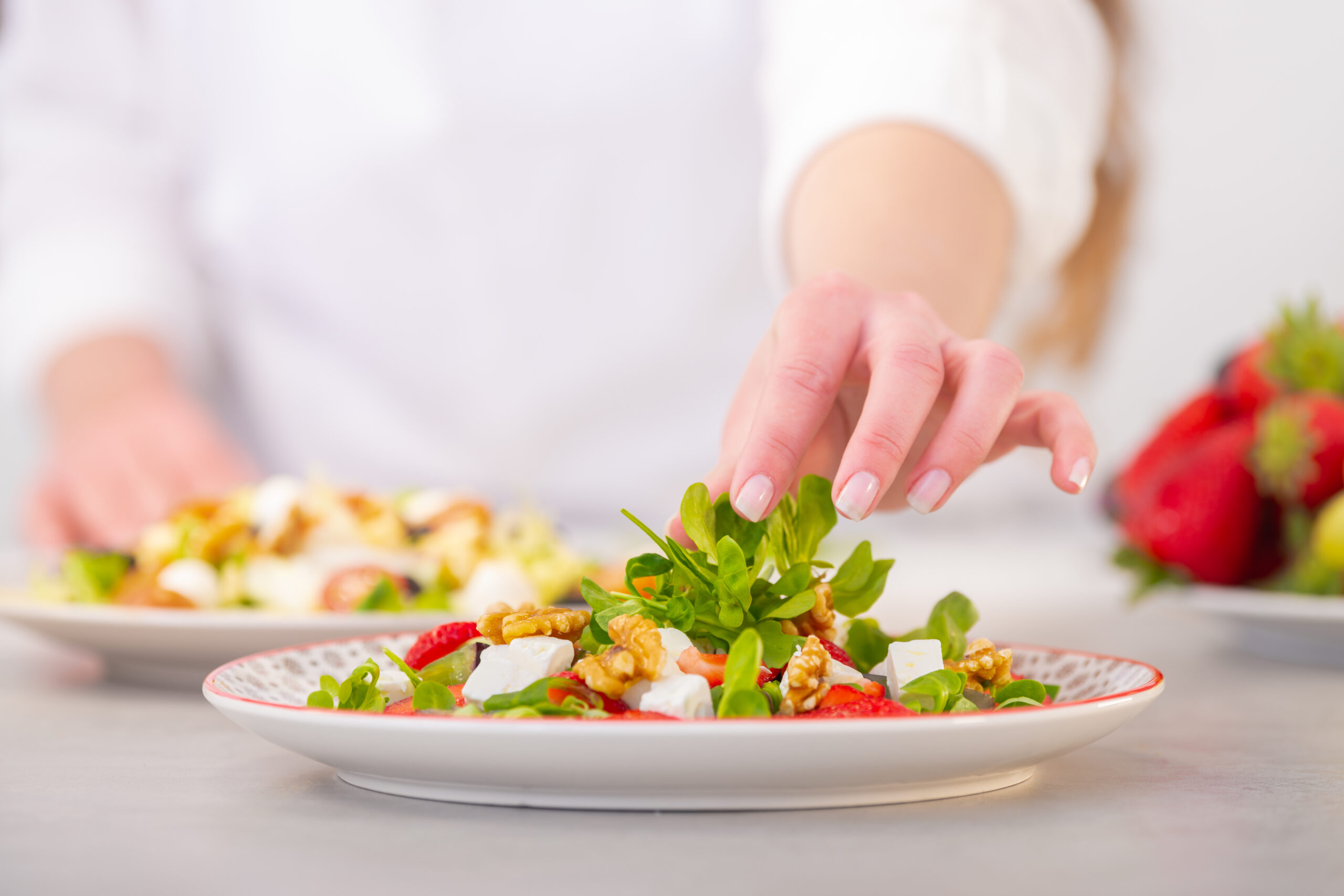 A Mediterranean diet salad with feta cheese, grape, nuts, and lettuce.